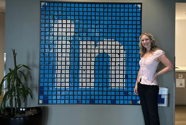 Ashley at the LinkedIn office in front of the logo wall